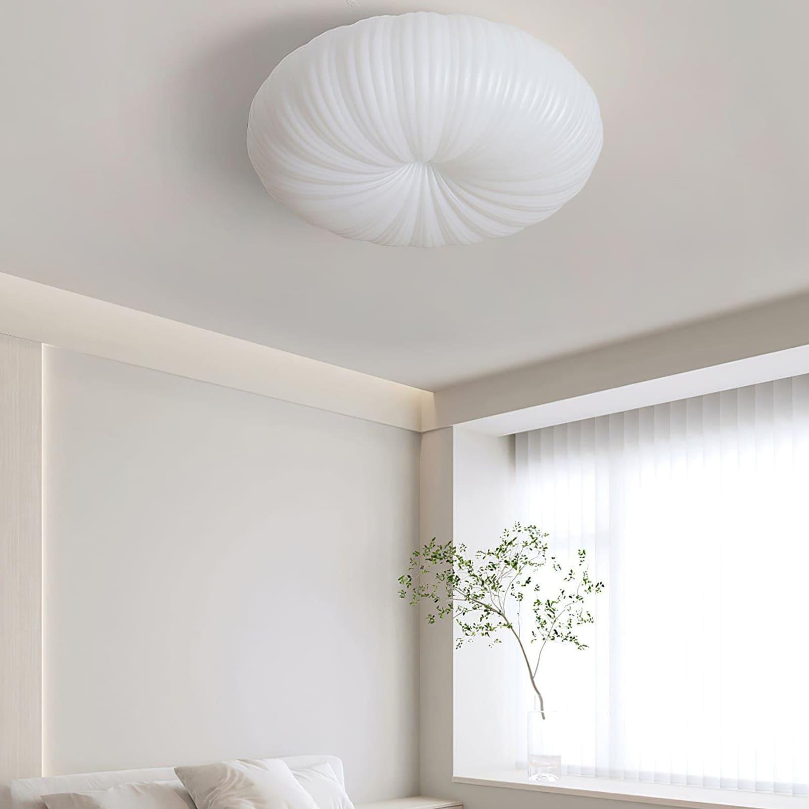 White Bobby flush ceiling light above minimal white bedroom with sheer curtains and branch in glass vase