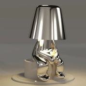 Silver RayDudes sunset lamp in awaited sitting pose on white display stand
