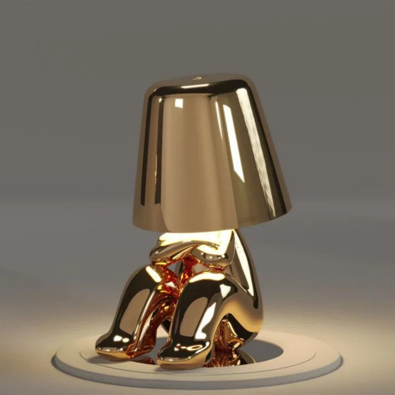 Gold RayDudes sunset lamp in baffled confounded crouching pose on white stand