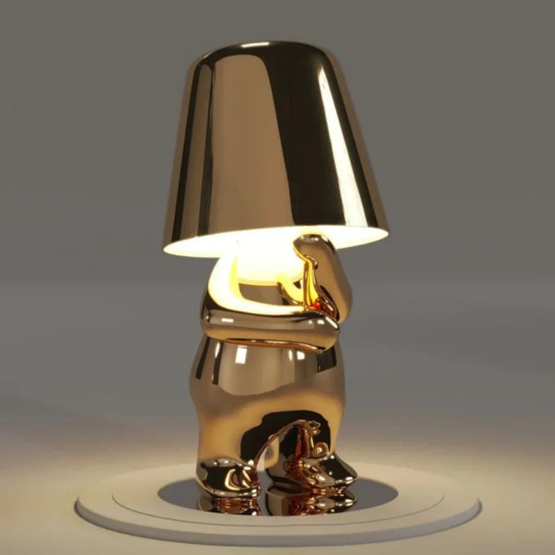 Gold RayDudes sunset lamp in contemplative thoughtful sitting pose on white stand