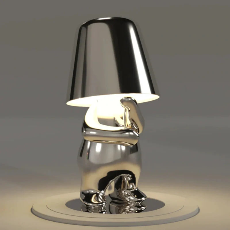 Silver RayDudes sunset lamp in contemplative thoughtful sitting pose on white stand