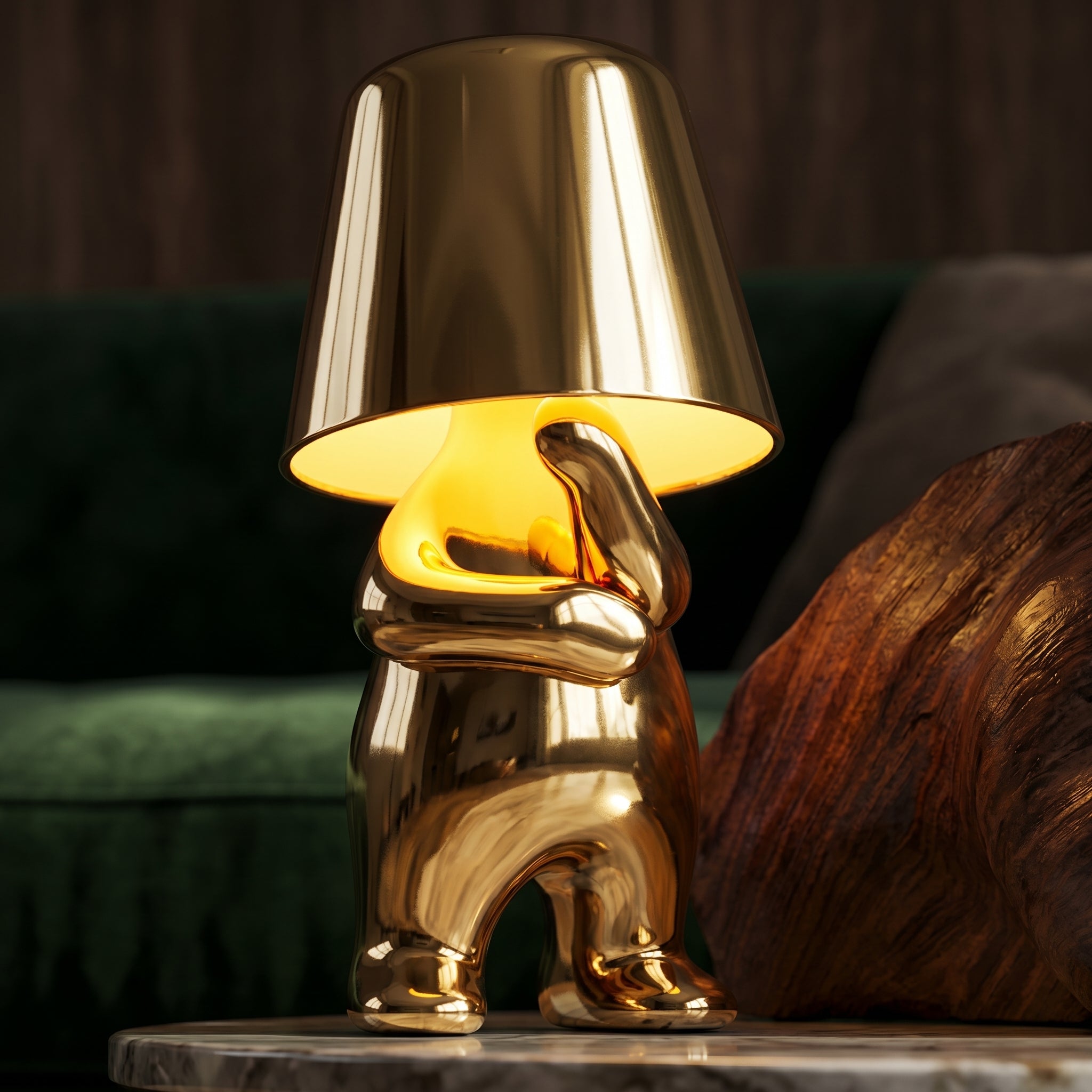 Close up of gold RayDudes sculptural table lamp glowing warm amber beside green velvet sofa