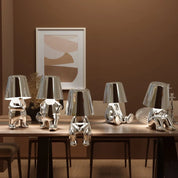 Multiple silver RayDudes sculptural lamps on marble cylinder pedestals in dark luxury interior