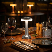 Silver retro bar table lamp as centerpiece on fine dining table with wine glasses and cutlery