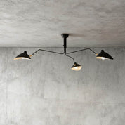 Black 3-arm Serge Mouille inspired ceiling light with brass joints on concrete ceiling product shot
