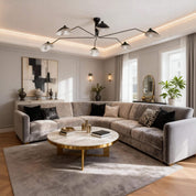 Black 6-arm Serge Mouille ceiling light in neutral living room with grey velvet sofa marble coffee table and abstract artwork